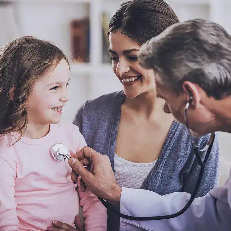 Child having a medical check-up with a doctor and parent in a clinic.