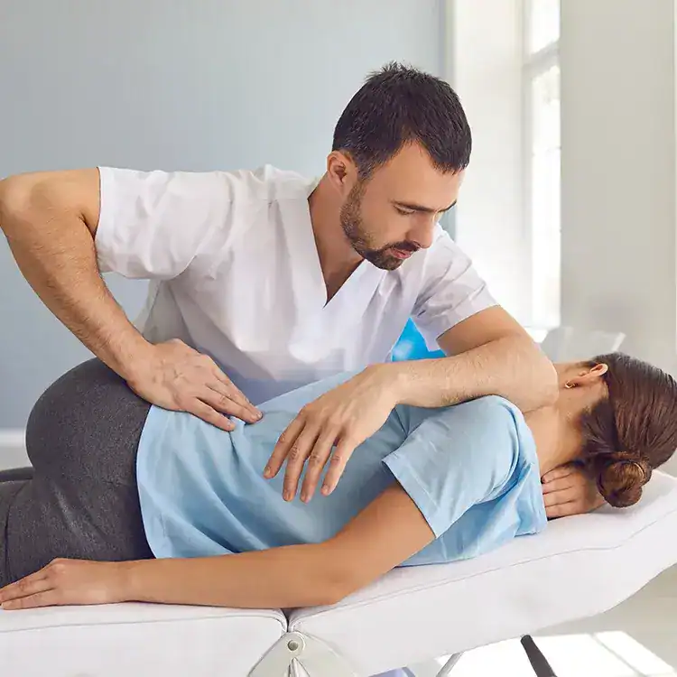 Physiotherapist providing treatment to a patient in a clinical setting.
